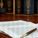 Documentos legales y una pluma sobre un escritorio de notario, representando la planificación testamentaria y optimización fiscal